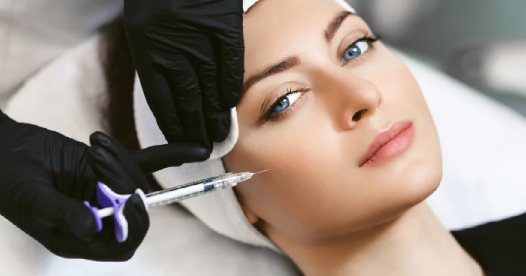 Woman receiving cheek filler injection by a gloved professional in Kaysville, UT
