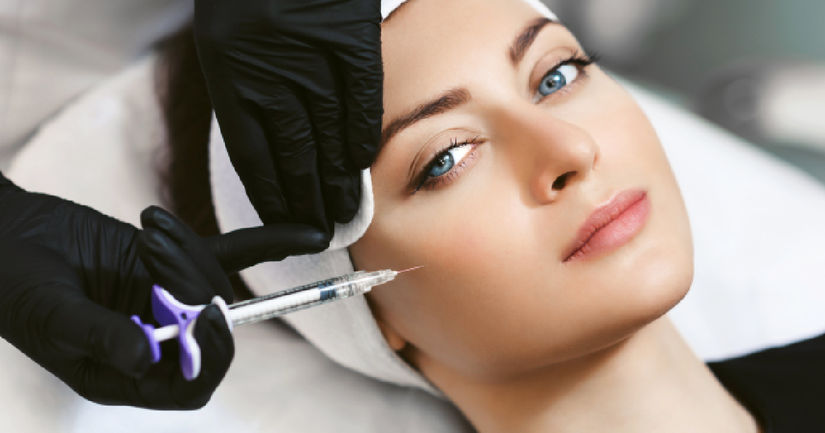 Woman receiving cheek filler injection by a gloved professional in Kaysville, UT